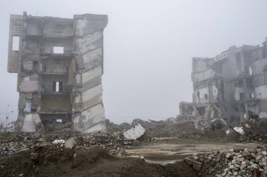 Sisli bir sis yıkılan binanın arka planda gri taş beton parçaları kalıntıları.