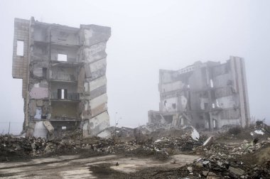 Sisli bir sis yıkılan binanın arka planda gri taş beton parçaları kalıntıları.