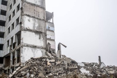 Gri beton kazık ve taşlar yıkılan binanın enkazı büyük bir yığın. Kopya alanı.
