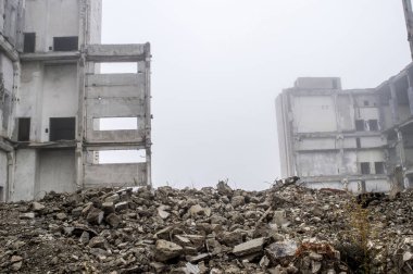 Sisli bir sis yıkılan binanın arka planda gri taş beton parçaları kalıntıları. Kopya alanı