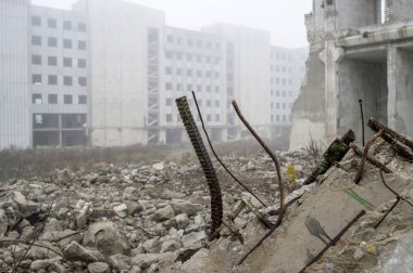 Biteviye-in takviye çıkıntılı beton kiriş beton enkaz ve binaların arka plan üzerinde yatıyor.