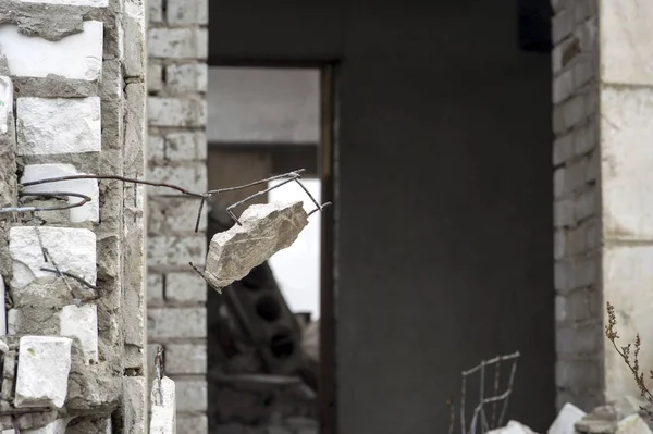 Entrada para o edifício de tijolos destruído com um pedaço de concreto pendurado em primeiro plano. Contexto. Espaço de cópia — Fotografia de Stock