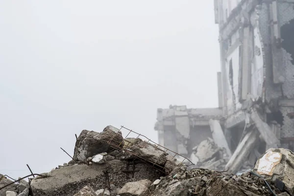 在雾蒙蒙的阴霾中 被毁建筑背景上的灰色石头的混凝土碎片的遗迹 破坏的影响 — 图库照片