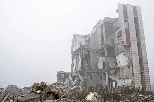在雾蒙蒙的阴霾中 被毁建筑背景上的灰色石头的混凝土碎片的遗迹 破坏的影响 — 图库照片