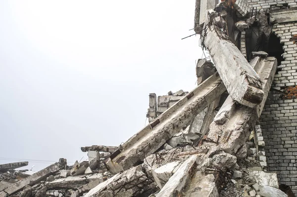 Gri beton kazık ve taşlar yıkılan binanın enkazı büyük bir yığın. Kopya alanı.