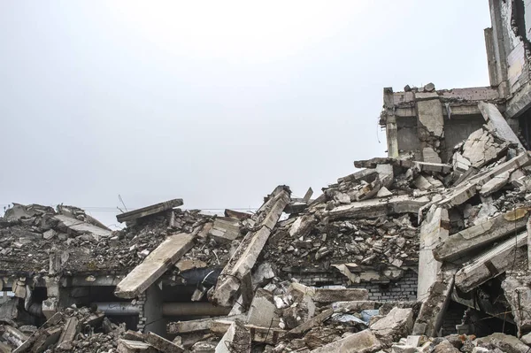 Gri beton kazık ve taşlar yıkılan binanın enkazı büyük bir yığın. İmha etkisi.