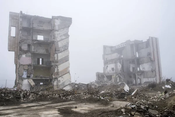 Sisli bir sis yıkılan binanın arka planda gri taş beton parçaları kalıntıları.