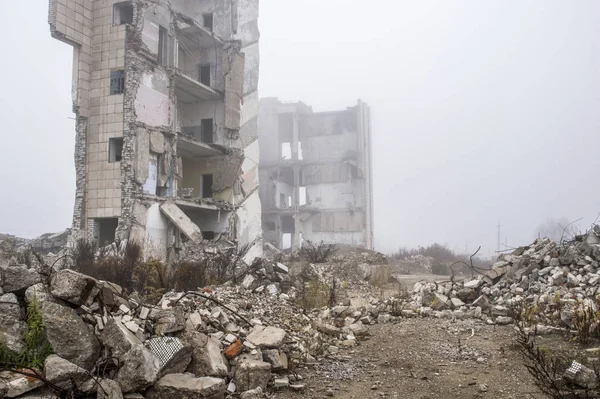 Sisli bir sis yıkılan binanın arka planda gri taş beton parçaları kalıntıları. Kopya alanı