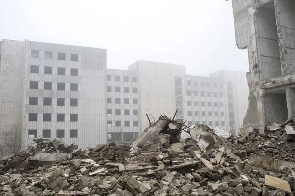 Sisli bir sis yıkılan binanın arka planda gri taş beton parçaları kalıntıları.