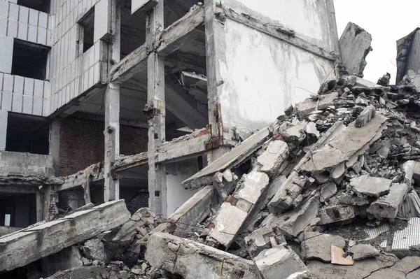 Uma enorme pilha de detritos de concreto cinza de pilhas e pedras do edifício destruído. O impacto da destruição . — Fotografia de Stock