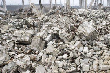 Büyük bir beton kazık ve taş yığınları parçaları şeklinde bina kalıntıları.