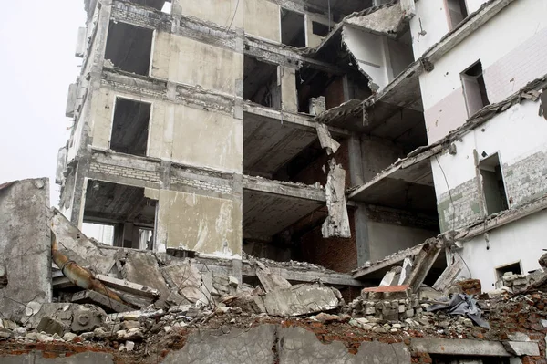 Os restos de um grande edifício de concreto na forma de fragmentos de pilhas e pilhas de pedras. Espaço de cópia . — Fotografia de Stock