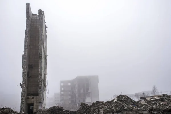De overblijfselen van de muur van een groot verwoeste gebouw tegen de achtergrond van andere verwoeste gebouwen. — Stockfoto