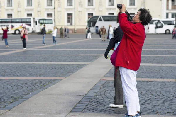 Kadın turist Doğu görünüm fotoğrafları üzerinde telefon konumlar üzerinde Palace square St Petersburg, Rusya, Eylül, 2018 — Stok fotoğraf