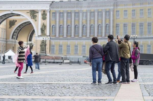 Bir kadın turist Doğu görünüm bir grup üzerinde Palace square St Petersburg, Rusya, Eylül, 2018 yurttaşlarının için poz — Stok fotoğraf