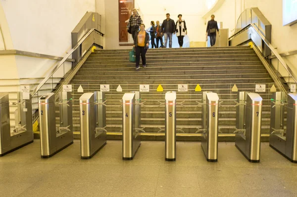 Desenfoque. La gente va al paso a través de torniquetes electrónicos en la estación de metro en San Petersburgo, Rusia, septiembre de 2018 — Foto de Stock