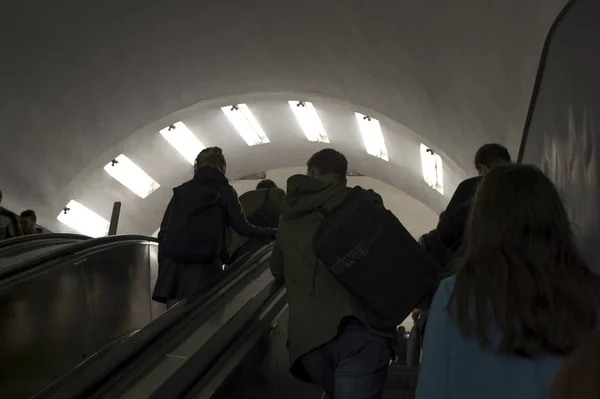 Desenfoque. La gente sube desde el túnel del metro en escaleras mecánicas a la luz en San Petersburgo, Rusia, septiembre de 2018 — Foto de Stock