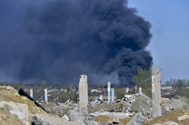 Mavi gökyüzünde kalın siyah duman arka planda Nervürlü çıkıntılı ile beton moloz yığını. Arka plan.