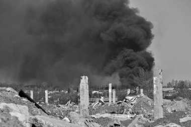 Mavi gökyüzünde kalın siyah duman arka planda Nervürlü çıkıntılı ile beton moloz yığını. Arka plan. Siyah beyaz görüntü