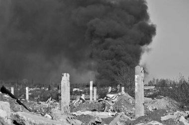 Mavi gökyüzünde kalın siyah duman arka planda Nervürlü çıkıntılı ile beton moloz yığını. Arka plan. Siyah beyaz görüntü