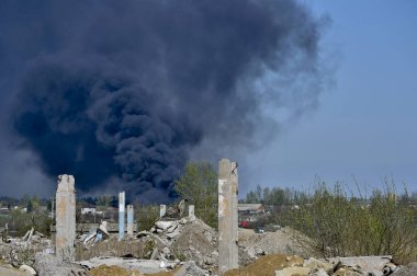 Mavi gökyüzünde kalın siyah duman arka planda Nervürlü çıkıntılı ile beton moloz yığını. Arka plan.