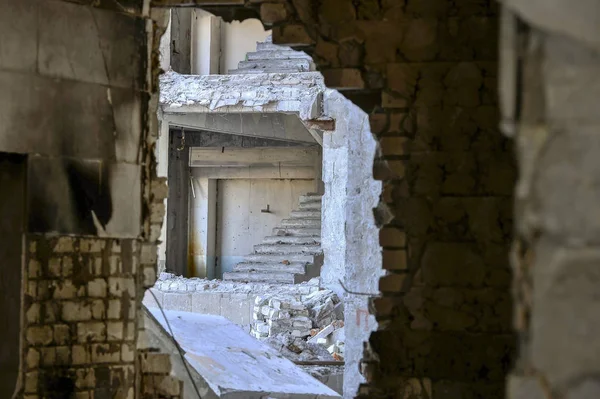 Vista de dentro através da parede quebrada para o próximo edifício destruído com um voo desencapado de escadas — Fotografia de Stock