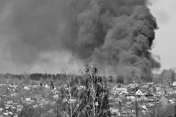 Humo de un incendio en las afueras de la ciudad en el sector privado. Blanco y negro —  Fotos de Stock