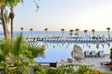 Kıbrıs 'ta Haziran 2017 yılında Coral Beach Hotel Resort Cyprus havuz kenarında şezlonglar bir dizi.