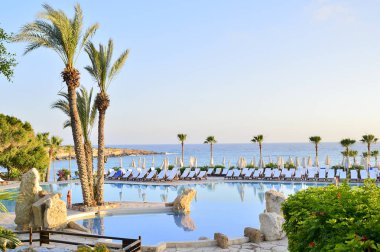Kıbrıs 'ta Haziran 2017 yılında Coral Beach Hotel Resort Cyprus havuz kenarında şezlonglar bir dizi.