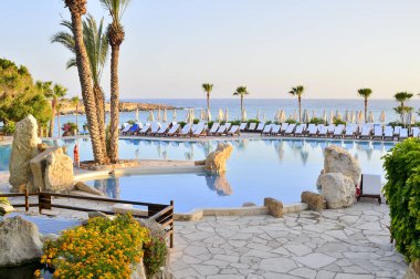 Kıbrıs 'ta Haziran 2017 yılında Coral Beach Hotel Resort Cyprus havuz kenarında şezlonglar bir dizi.