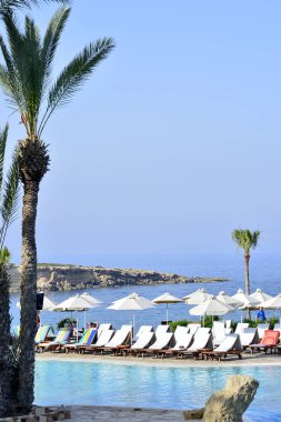 Kıbrıs 'ta Haziran 2017 yılında Coral Beach Hotel Resort Cyprus havuz kenarında şezlonglar bir dizi.