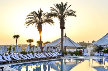 Kıbrıs 'ta Haziran 2017 yılında Coral Beach Hotel Resort Cyprus havuz kenarında şezlonglar bir dizi.