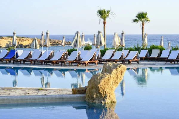Kıbrıs 'ta Haziran 2017 yılında Coral Beach Hotel Resort Cyprus havuz kenarında şezlonglar bir dizi.