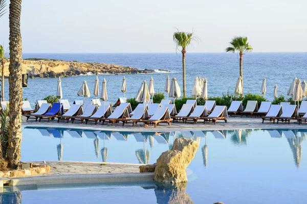 Kıbrıs 'ta Haziran 2017 yılında Coral Beach Hotel Resort Cyprus havuz kenarında şezlonglar bir dizi.