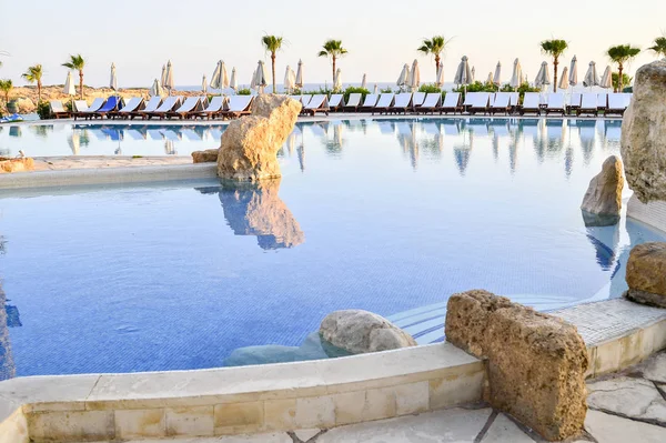 Kıbrıs 'ta Haziran 2017 yılında Coral Beach Hotel Resort Cyprus havuz kenarında şezlonglar bir dizi.