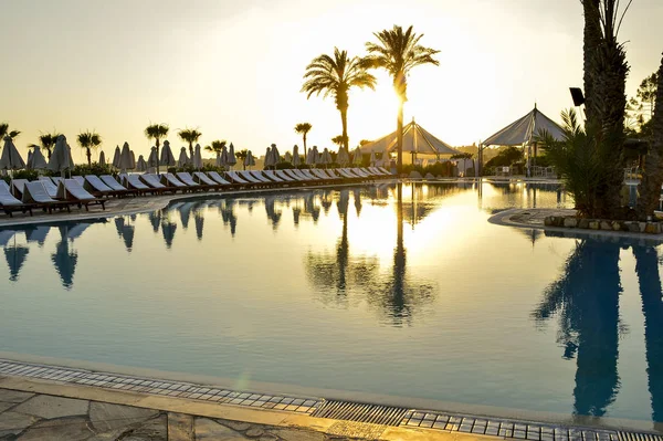 Kıbrıs 'ta Haziran 2017 yılında Coral Beach Hotel Resort Cyprus havuz kenarında şezlonglar bir dizi.