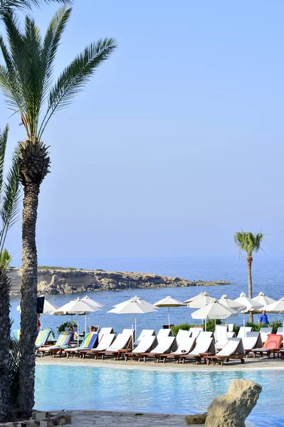 Kıbrıs 'ta Haziran 2017 yılında Coral Beach Hotel Resort Cyprus havuz kenarında şezlonglar bir dizi.
