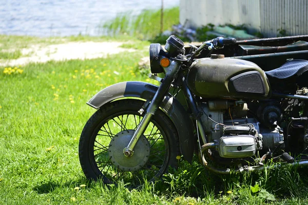 Motocykl radziecki Dniepr na zielonej trawie przedniej części Zamknij przeciwko piaszczysty brzeg jeziora — Zdjęcie stockowe