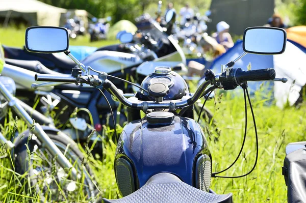 Wiele zaparkowanych motocykli na zielonej trawie na festiwalu rowerzystę. Koncepcja rowerzystów stylu życia: prędkość i droga — Zdjęcie stockowe