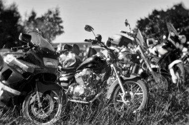 Bulanık -lık. Özel bir yumuşak lens siyah beyaz fotoğraf. Motosikletler otoparkta üst üste sıraya dizildi. Konsept: tatilde uçan hayaletler
