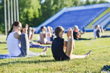 Yumuşak lens bulanıklığı. Annesiyle bir kız şehir stadyumunda jimnastik egzersizleri yapar, Rusya, Kursk bölgesi, Zheleznogorsk, Haziran 2018