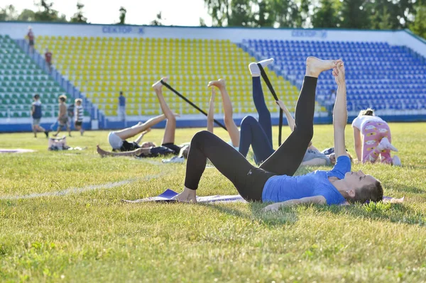 Młoda kobieta wykonuje ćwiczenia jogi gimnastyki na stadionie miejskim, Rosja, region Kursk, Zheleznogorsk, czerwiec 2018 — Zdjęcie stockowe