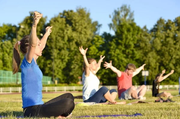 Yoga exercises class breathing technique group of people at the city stadium Russia, Kursk region, Zheleznogorsk, June 2018.