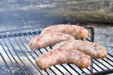 Domuz sosisızgara üzerinde kömürler üzerinde kavrulur.