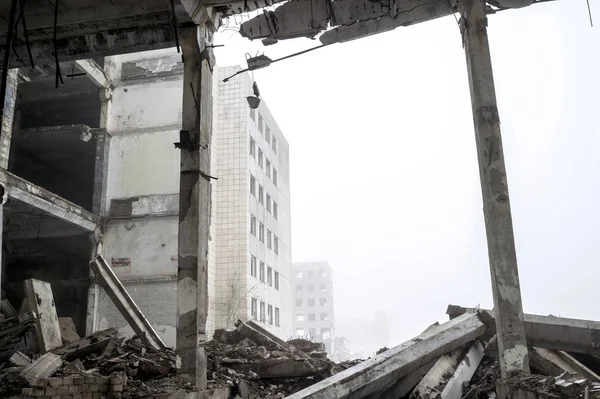 Het vernietigde grote betonnen gebouw in een mistige nevel. Achtergrond. — Stockfoto
