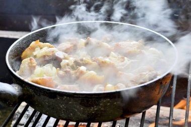 Izgara soğan ile bir tavada et pişirme. Kızarmış domuz eti