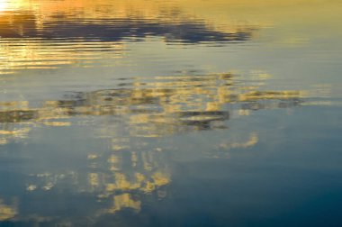 Bulanık, arka plan su yüzeyine akşam gökyüzünün yansıması ile