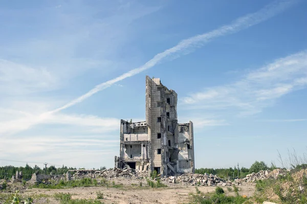 The destroyed big building under demolition against the textured blue sky. Background.