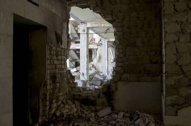 Beton bir binanın yıkılmış yapısının arka plan üzerinde tuğla duvardelik delik. Arka plan