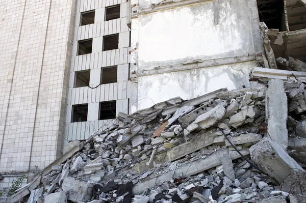 Destruyó un gran edificio con un bloqueo de escombros de hormigón en primer plano. Contexto —  Fotos de Stock